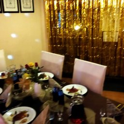 KAERTUR SPÓŁKA Z OGRANICZONĄ ODPOWIEDZIALNOŚCIĄ - Uroczysty stół z dekoracjami świątecznymi, nakryty dla gości, z elementami dekoracyjnymi w postaci figurek skrzatów i złotych frędzli w tle.