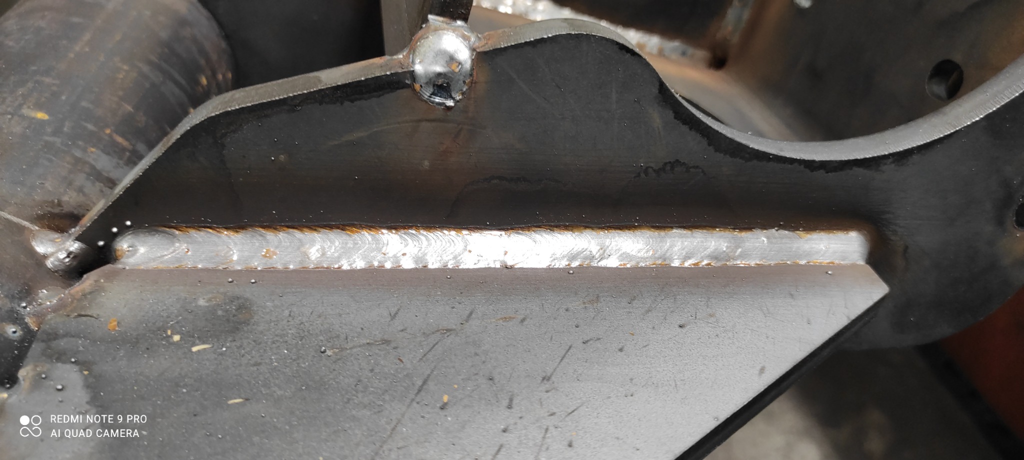 Spoina łącząca metalowe elementy konstrukcyjne, widoczne ślady obróbki i niewielkie odpryski.