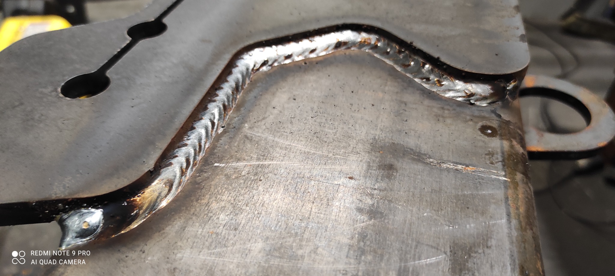 Metalowy element z widocznym spoiwem po procesie łączenia, z bliska, z widocznymi śladami obróbki.