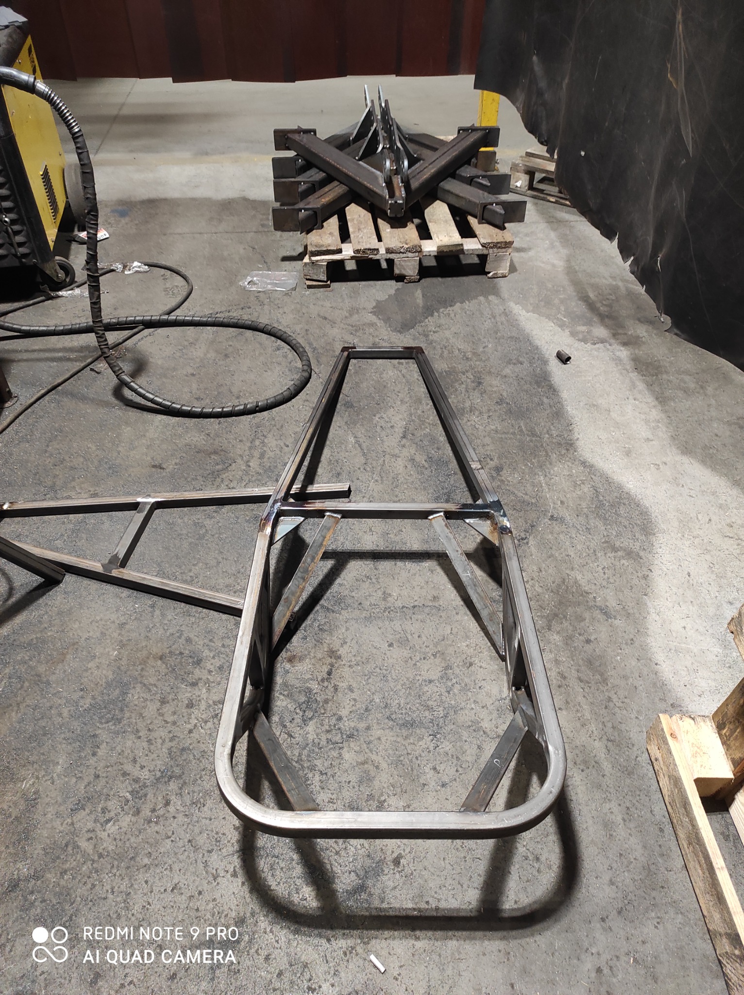 Spawanie ramy z metalowych profili w warsztacie w Białymstoku, widoczne spawy, paleta z elementami konstrukcyjnymi w tle.