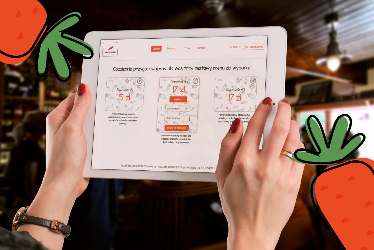 Kobieta przegląda menu cateringu dietetycznego dla dzieci na tablecie. Widoczne są trzy opcje obiadowe z cenami i krótkimi opisami. Tło rozmyte, sugeruje wnętrze restauracji lub kawiarni.