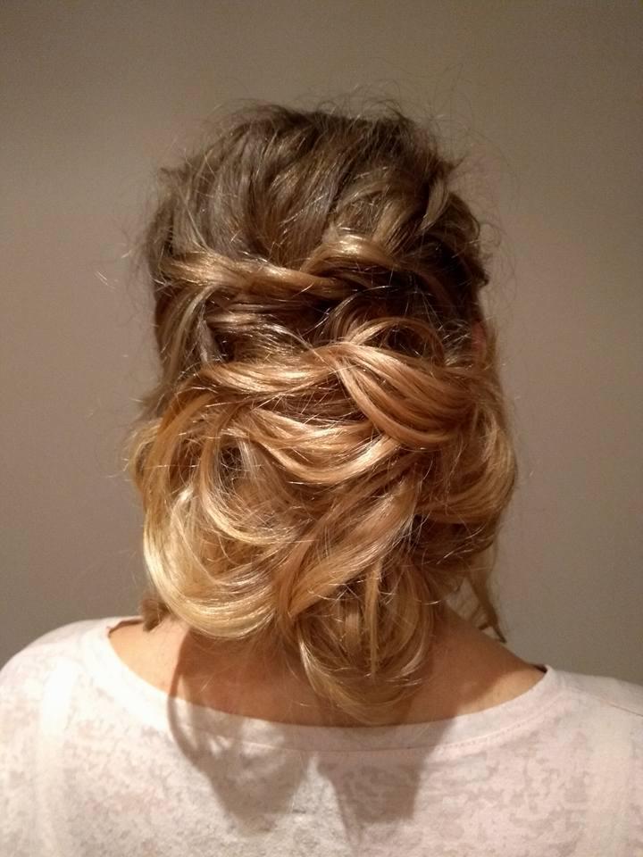 Upięcie włosów z tyłu głowy, z widocznymi skręconymi pasmami i delikatnymi falami, włosy ombre przechodzące od ciemnego blondu u nasady do jaśniejszych końcówek.