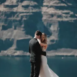 Para młoda w objęciach na tle malowniczego, skalistego krajobrazu z jeziorem, uchwycona w ciepłym, naturalnym świetle.