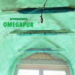 Rehouse MK - Aplikacja izolacji pianką na poddaszu z widocznym logo wykonawcy Omegapur i elementami drewnianej konstrukcji oraz przewodami elektrycznymi.