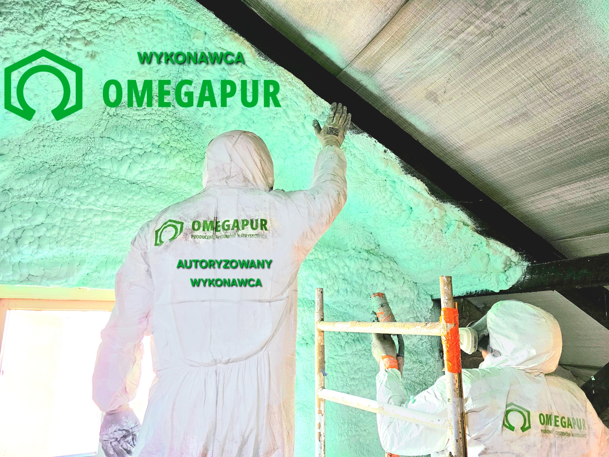 Pracownicy w kombinezonach ochronnych aplikują piankę PUR na poddaszu, widoczna struktura pianki i logo firmy wykonawczej OMEGAPUR na kombinezonach.
