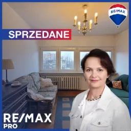 Salon z widokiem na okno, sofa w kwiaty i zielony szezlong, kobieta w białej kurtce i logo RE/MAX z napisem SPRZEDANE.