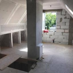 Pro-Bud system - Surowe wnętrze poddasza w Brzegu w trakcie remontu, widoczne ściany z bloczków, płyty kartonowo-gipsowe, przygotowane otwory w podłodze i pion kanalizacyjny.