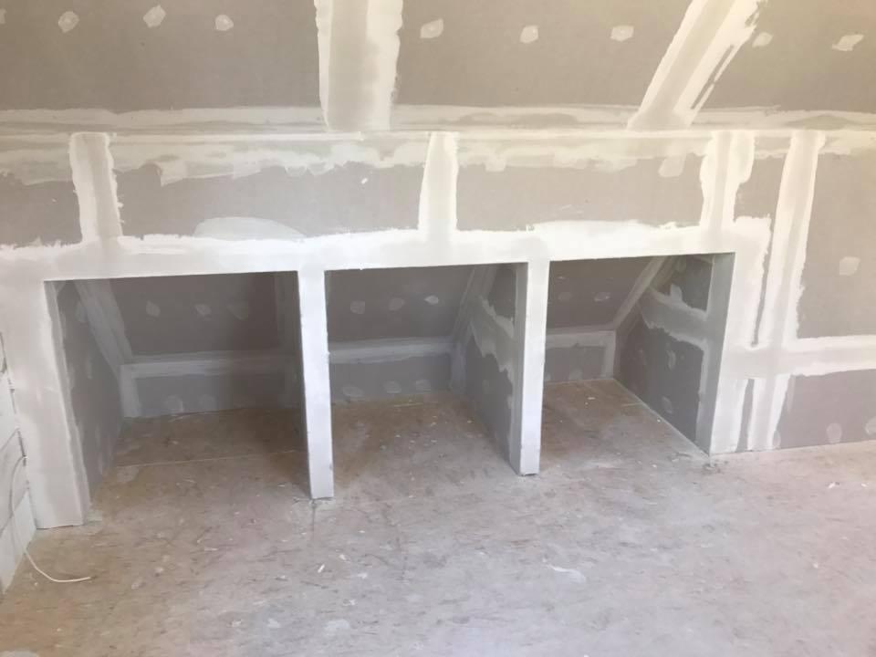 Niewykończona wnęka z płyt kartonowo-gipsowych w poddaszu, szpachlowana, gotowa do malowania, widoczne niedoskonałości na podłodze.