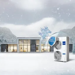 Biała, dwuwentylatorowa jednostka zewnętrzna z funkcją Anti Freezing marki Haier na tle nowoczesnego domu w zimowej scenerii.