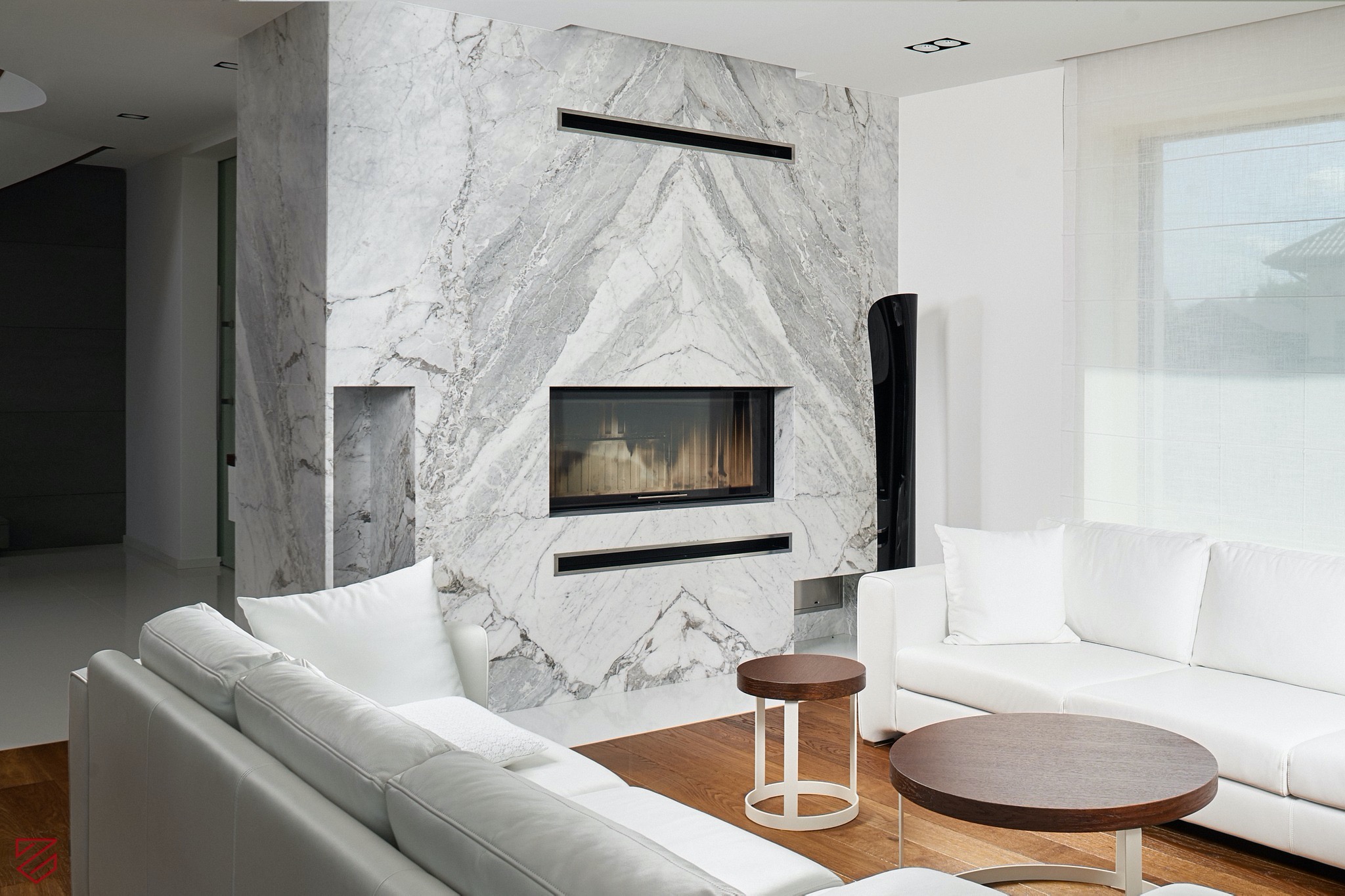 Kominek obłożony marmuru Carrara Bianco w formie lustrzanego odbicia.