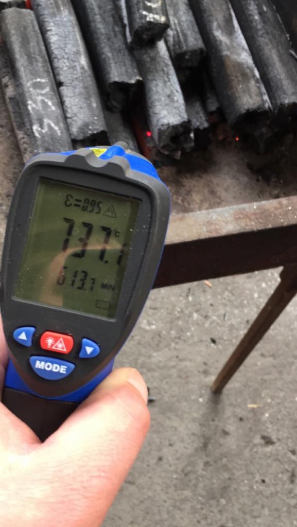 Pomiar temperatury brykietów Pini Kay pirometrem laserowym, wyświetlającym 73.7 stopni Celsjusza.