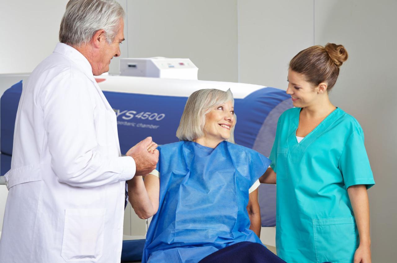 Pacjentka w trakcie sesji w komorze hiperbarycznej YS4500, wspierana przez lekarza i pielęgniarkę, uśmiechnięta i zrelaksowana.