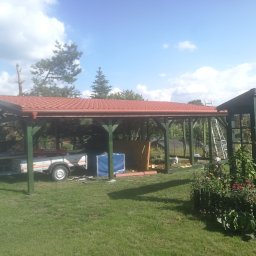 MAT-WOOD - Montaż zadaszenia tarasu z czerwoną dachówką, widoczna przyczepka z materiałami budowlanymi i drabina oparta o konstrukcję.