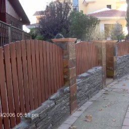 Ogrodzenie wykonane z kamienia naturalnego i drewna egzotycznego