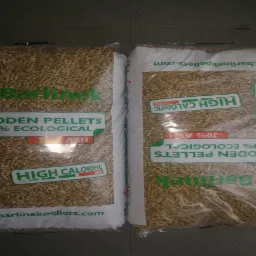 Dwa worki transparentne wypełnione jasnymi, drobnymi granulkami z napisem 'Barlinek Wooden Pellets 100% Ecological -30% Ash High Calorific Max' oraz certyfikatami jakości DINplus i ENplus A1...