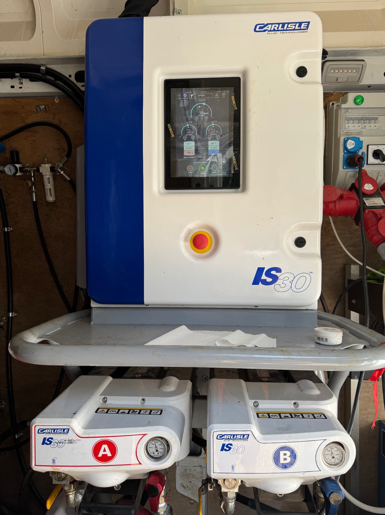 Maszyna Carlisle IS30 z ekranem dotykowym i dwoma modułami A i B. Widoczne wskaźniki i elementy sterujące. Sprzęt wewnątrz pojazdu.