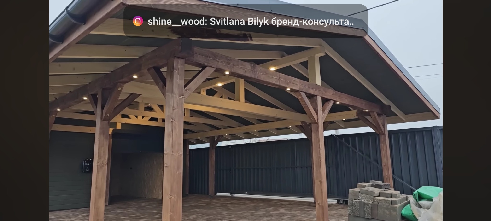 Drewniana konstrukcja z oświetleniem punktowym, prawdopodobnie zadaszenie lub altana, w trakcie budowy, widoczne elementy konstrukcyjne oraz materiały budowlane