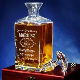 Karafka z whisky z grawerem 'Mariusz', 'Old No.30' i 'Wszystkiego najlepszego', leżący korek obok, na drewnianej skrzynce z metalowym zapięciem, na tle ciemnoniebieskim.