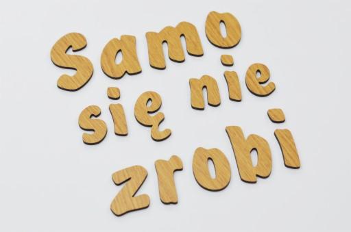 Drewniane litery układające się w napis 'Samo się nie zrobi' na białym tle, potencjalna motywacja do działania dla firm z Wodzisławia Śląskiego.