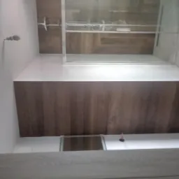 Nowoczesna łazienka z prysznicem typu walk-in, wykończona płytkami imitującymi drewno na ścianach i białymi płytkami na podłodze, widok z góry.