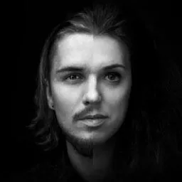 Portret w czerni i bieli, przedstawiający połączenie dwóch twarzy: męskiej z krótką brodą i kobiecej z długimi włosami, tworzących iluzję androgynicznej postaci.