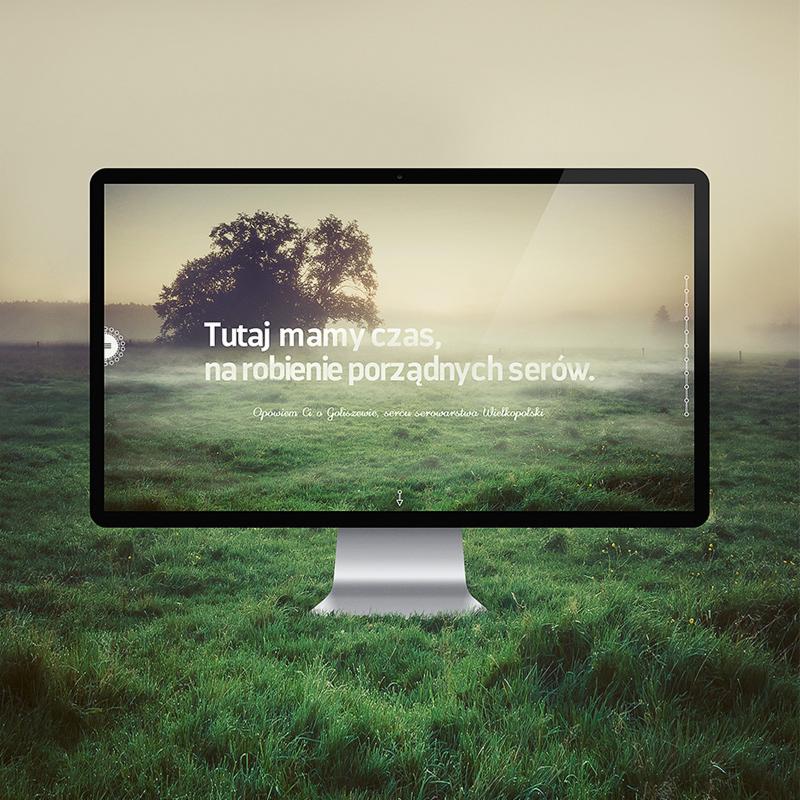 Ekran monitora prezentuje projekt strony internetowej dla polskiej marki Sery z Goliszewa, z widocznym hasłem 'Tutaj mamy czas, na robienie porządnych serów' na tle mglistego krajobrazu z drzewem.