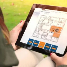 Osoba trzymająca tablet z wyświetloną stroną internetową z rzutem mieszkania Osiedla Dębowe Apartamenty, blok A, drugie piętro.