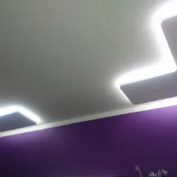 Nowoczesny sufit podwieszany z podświetleniem LED w kształcie litery L, fioletowa ściana, kryształowy żyrandol.