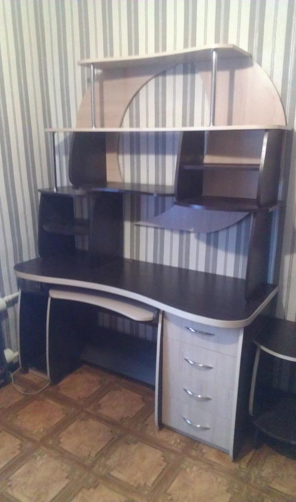 Biurko komputerowe z nadstawką w odcieniach brązu i beżu, z trzema szufladami, na tle ściany w pionowe pasy.