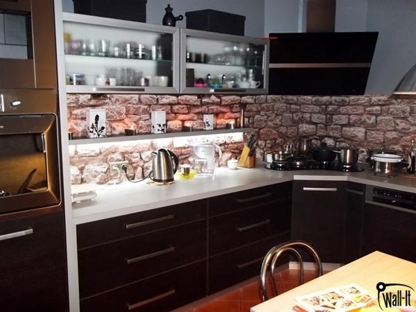 Kuchnia w Świdnicy z okładziną ścienną imitującą cegłę, szklane szafki wiszące i ciemne, nowoczesne meble kuchenne.