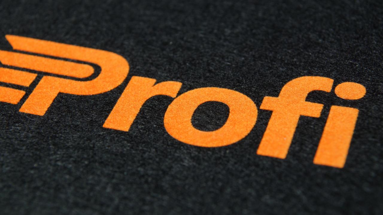 Czarny materiał z pomarańczowym, flockowanym napisem 'Profi' z charakterystycznym, stylizowanym 'P'.