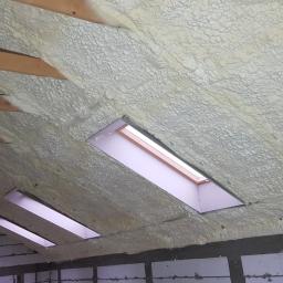 Termoprof Dawid Osiński - Poddasze w Tczowie po natrysku pianki poliuretanowej, widoczne drewniane belki i okna dachowe przed wykończeniem.