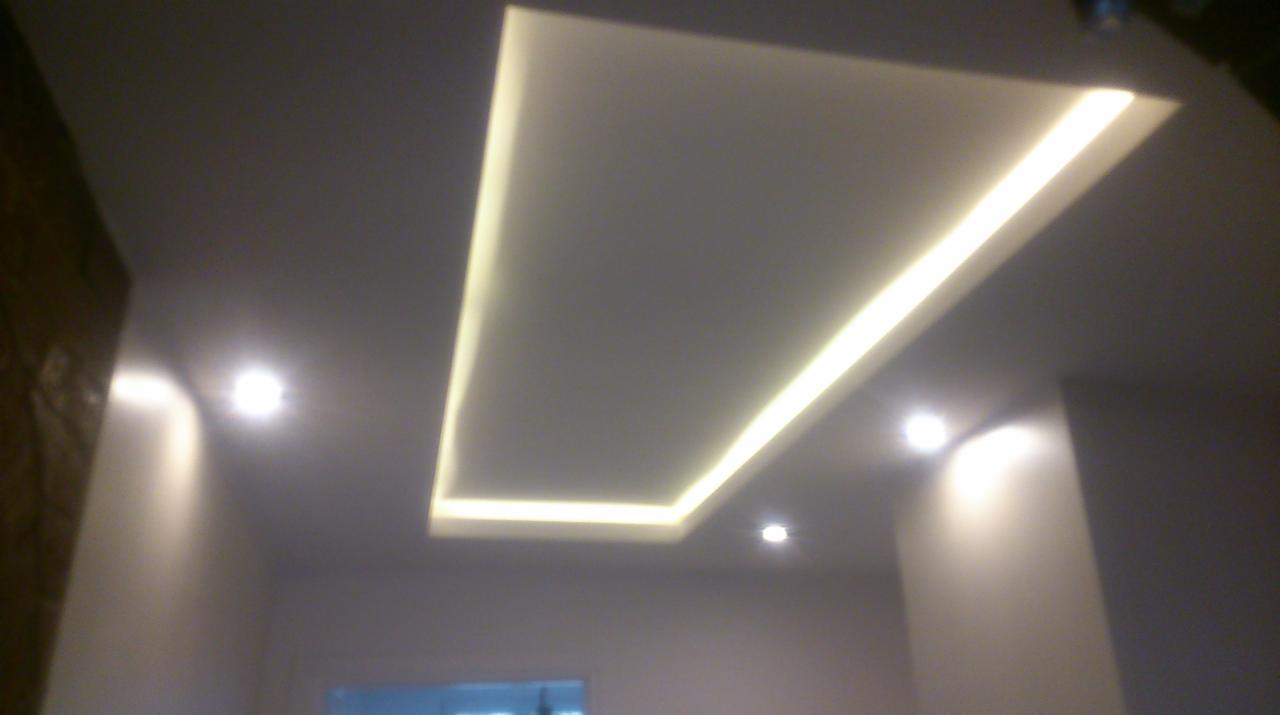 Nowoczesny sufit podwieszany z oświetleniem LED w kształcie prostokąta, dodatkowo oświetlenie punktowe, widok z dołu.