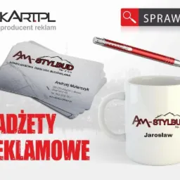 Reklamowe gadżety: wizytówki z projektem budowlanym, długopis i biały kubek z logo firmy AM-STYLBUD na neutralnym tle.
