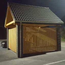 Zadaszone miejsce parkingowe z drewnianą konstrukcją i czarną dachówką, oświetlone sztucznym światłem nocą, z zaparkowanym samochodem w tle.