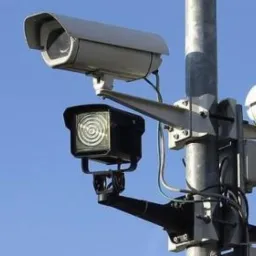 Dwie kamery kopułkowe i dwie kamery z oświetlaczami IR zamontowane na metalowym słupie na tle błękitnego nieba.