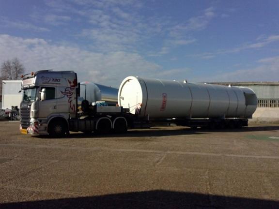 Ciężarówka Scania 730 przewożąca biały, cylindryczny zbiornik z widocznym napisem na naczepie, zaparkowana na placu w słoneczny dzień.