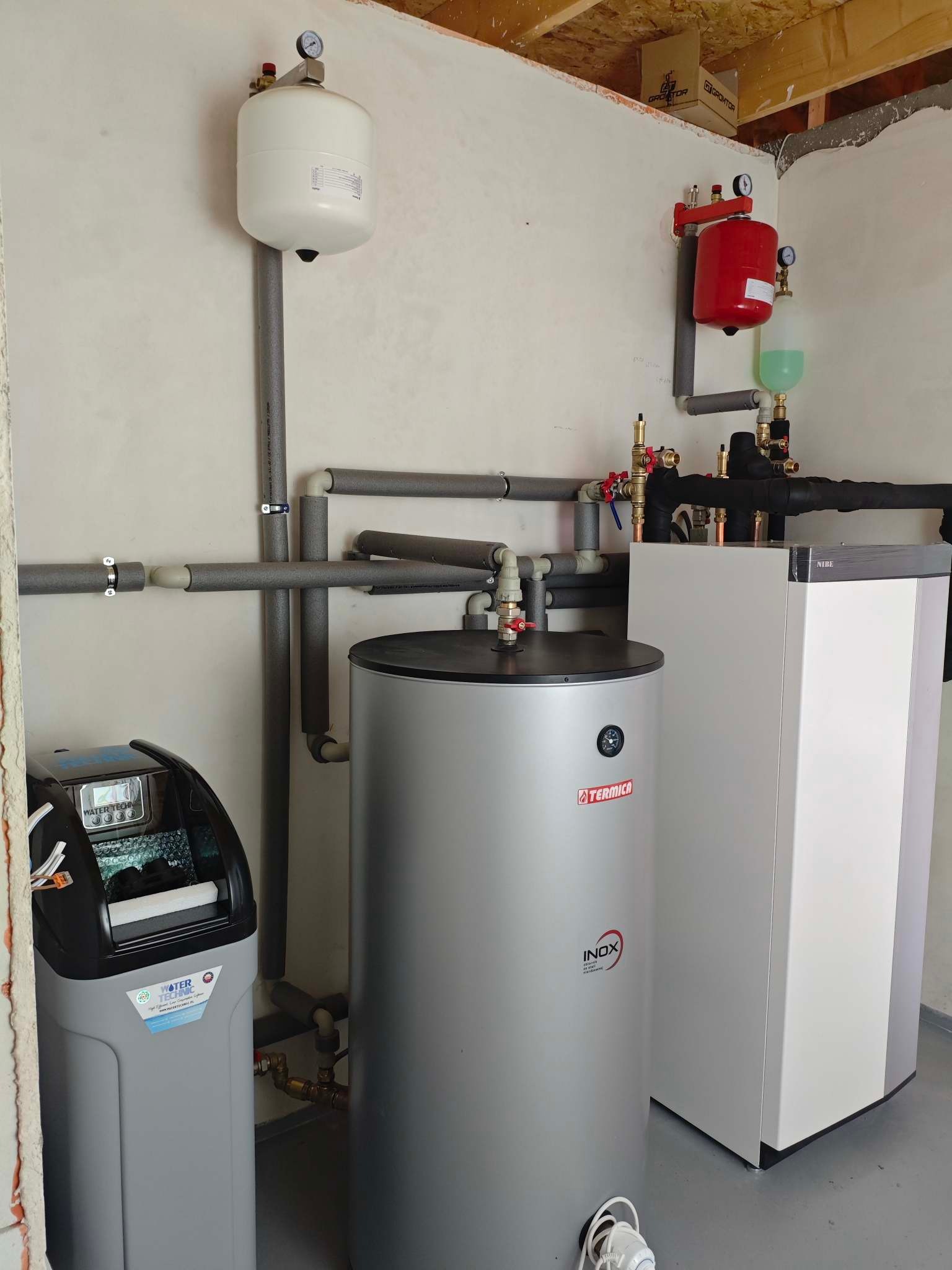 Zestaw instalacji grzewczej z zbiornikiem Termica Inox i zmiękczaczem wody Water Technic we Wrocławiu. Rury w izolacji, manometry i zawory.
