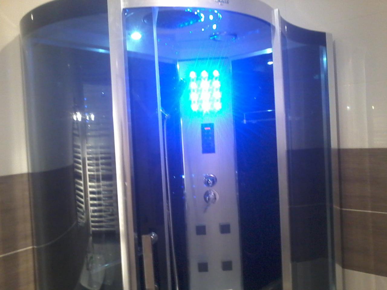 Kabina prysznicowa z hydromasażem i niebieskim oświetleniem LED, zamontowana w łazience w Ułanowicach, z widocznymi brązowo-białymi płytkami na ścianie.