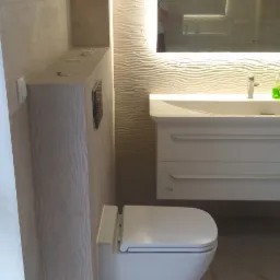 Nowoczesna toaleta podwieszana z zabudową w płytkach o falującej fakturze, dopasowana do ściany z lustrem z podświetleniem LED i umywalką z szafką w tle.