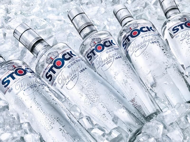 Kilka butelek wódki w lodzie, lekko pochylone, z widocznymi kroplami kondensacji, eksponujące etykiety 'Stock Prestige'.