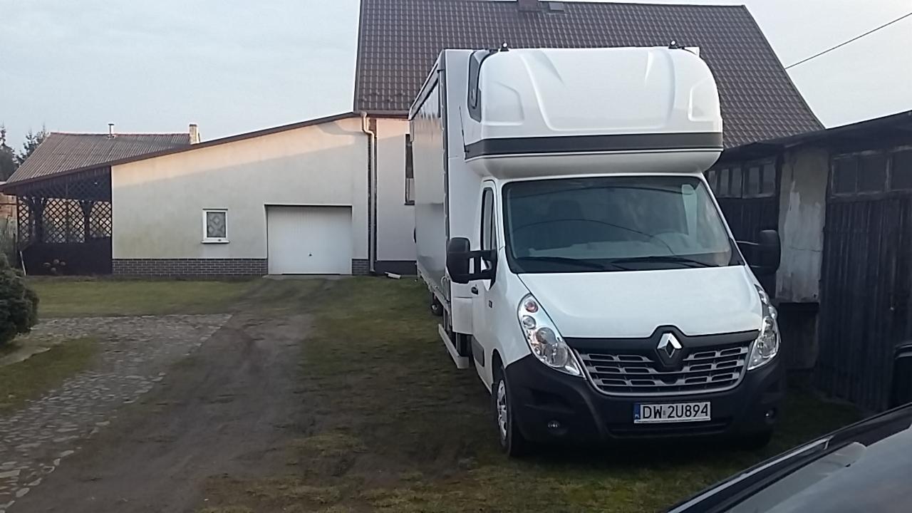 Biały bus Renault Master z zabudową kontenerową na posesji, widoczny numer rejestracyjny DW 2U894.