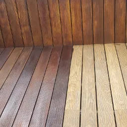 Fragment tarasu kompozytowego z desek w dwóch odcieniach brązu, gdzie jedna część jest jaśniejsza, a druga ciemniejsza, ukazując różnicę w kolorze i wykończeniu.