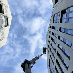 AquaUp - Prace wysokościowe przy czyszczeniu fasady hotelowej. Stabilny podnośnik zapewnia precyzję i bezpieczeństwo.