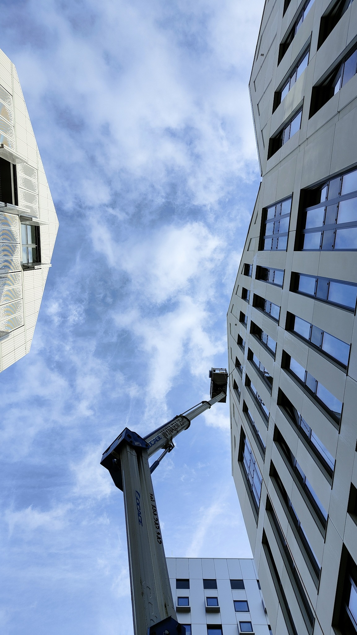 Prace wysokościowe przy czyszczeniu fasady hotelowej. Stabilny podnośnik zapewnia precyzję i bezpieczeństwo.