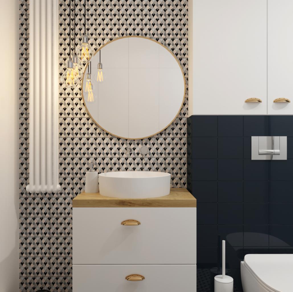 Nowoczesna łazienka z okrągłym lustrem, umywalką nablatową na białej szafce z drewnianym blatem, czarno-białymi wzorzystymi płytkami na ścianie oraz wiszącymi żarówkami typu Edison.