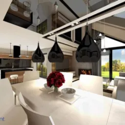 Wnętrze nowoczesnego domu z jadalnią: biały stół z dekoracją kwiatową, czarne wiszące lampy, kuchnia w tle i widok na ogród przez duże okno.