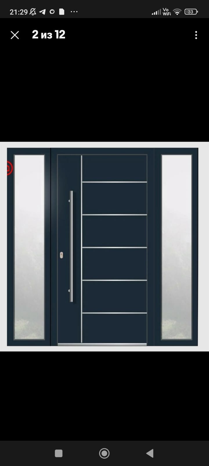 Nowoczesne drzwi wejściowe w kolorze antracytowym z bocznymi naświetlami i długim, pionowym uchwytem ze stali nierdzewnej.