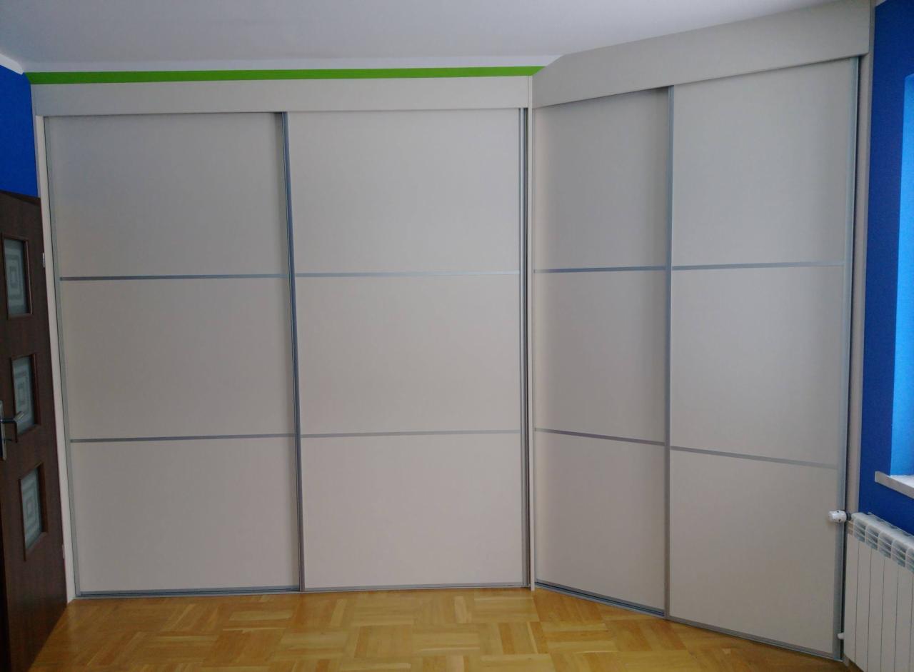 Zabudowa narożna z przesuwnymi drzwiami w kolorze kremowym, zrealizowana w Krakowie, z widocznymi poziomymi podziałami na frontach.