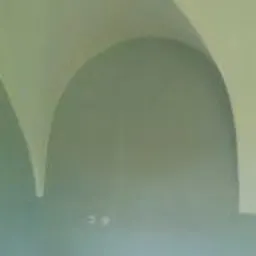 Wnętrze pomieszczenia z łukowym sufitem po świeżo wykonanych pracach wykończeniowych, widoczne gładkie, pomalowane ściany w odcieniach zieleni i błękitu, z delikatnym przejściem kolorystycznym.